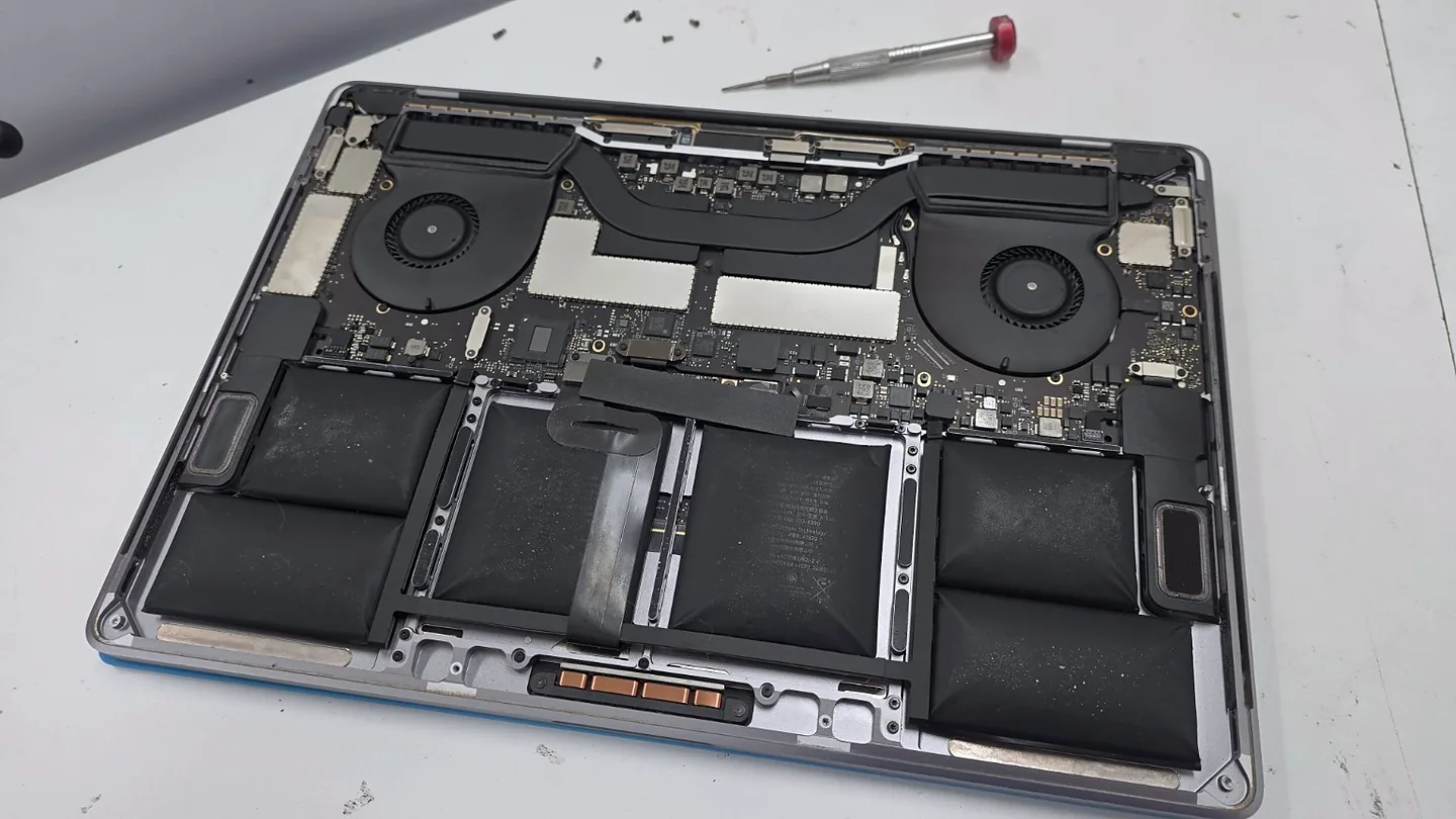 Opened MacBook showing its battery, cooling fans and circuit board